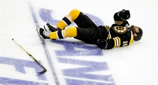Boston Bruins right wing Nathan Horton lies on the ice after being checked by the Vancouver Canucks' Aaron Rome.